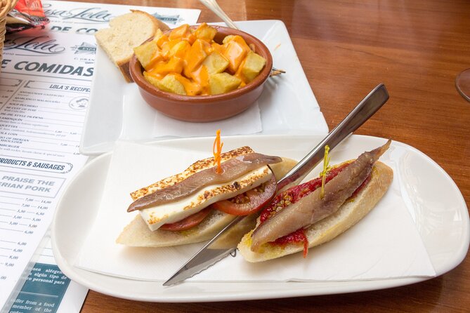 Malaga Food Tour: Tapas, Drinks and Delights with a Local - Near the Picasso Museum: choosing between pork cheeks, tuna, and goat stew